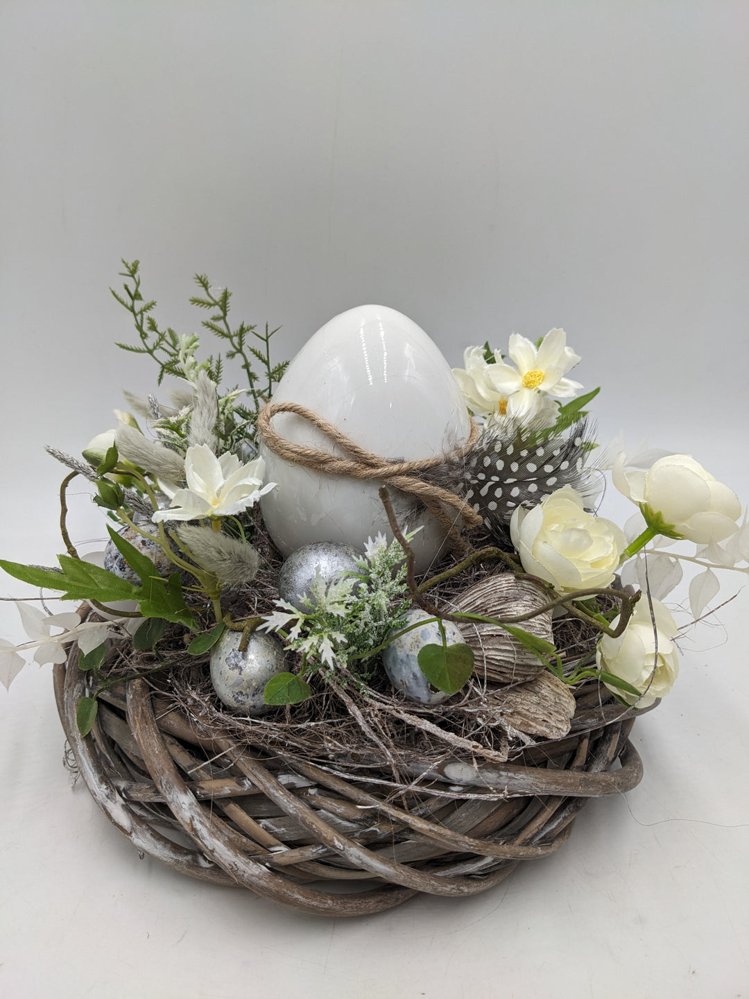Ostergesteck Frühlingsgesteck Ranunkel Ei Feder weiss