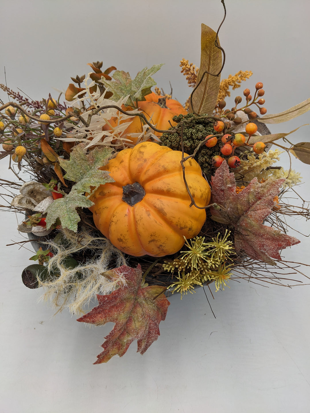 Herbstgesteck Kürbis Beeren orange