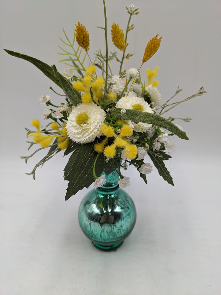 Frühlingsgesteck Vase Gräser Bellis türkis gelb