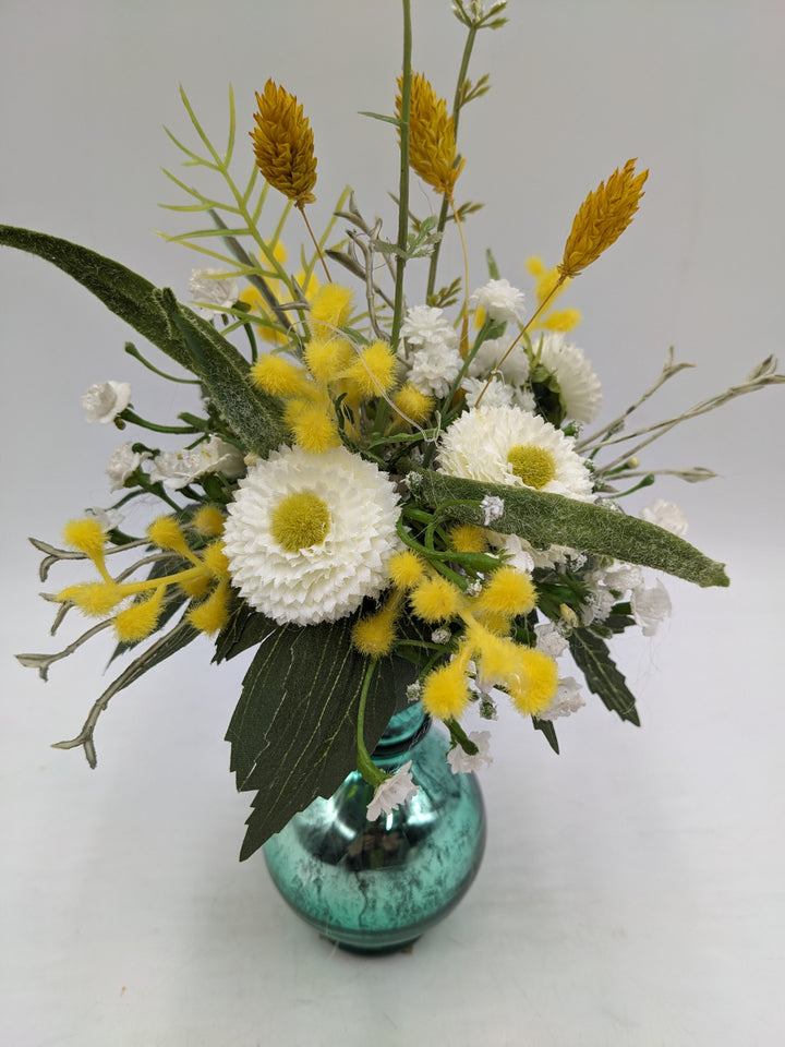 Frühlingsgesteck Vase Gräser Bellis türkis gelb