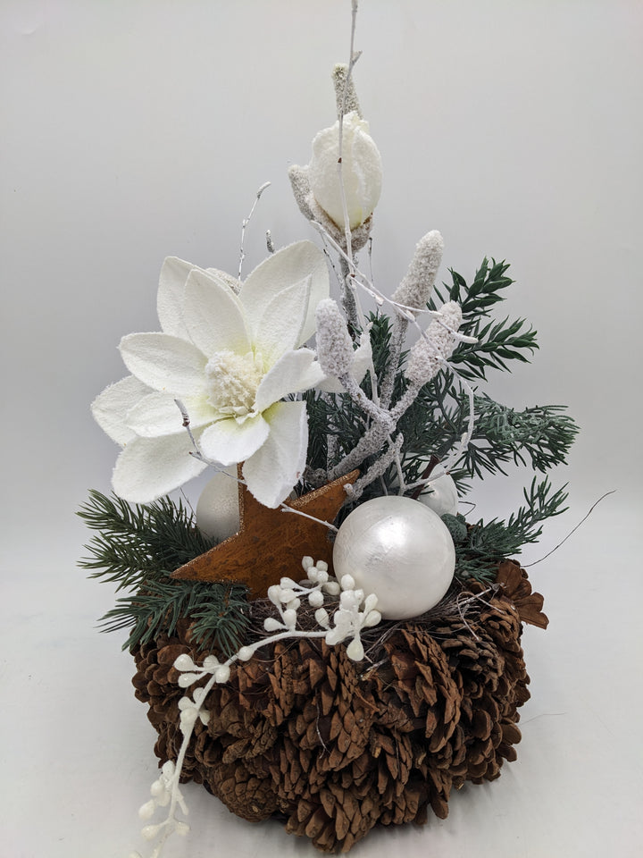 Weihnachtsgesteck Magnolie Zapfen Stern beschneit