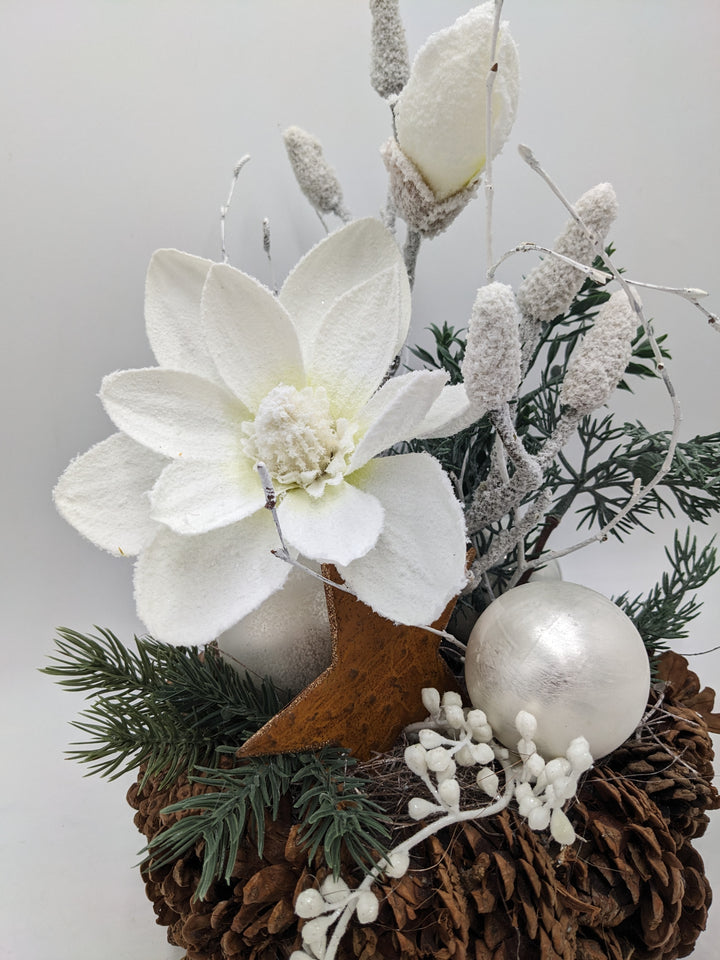 Weihnachtsgesteck Magnolie Zapfen Stern beschneit