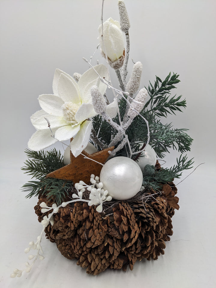 Weihnachtsgesteck Magnolie Zapfen Stern beschneit