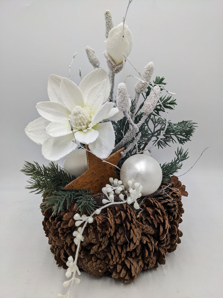 Weihnachtsgesteck Magnolie Zapfen Stern beschneit