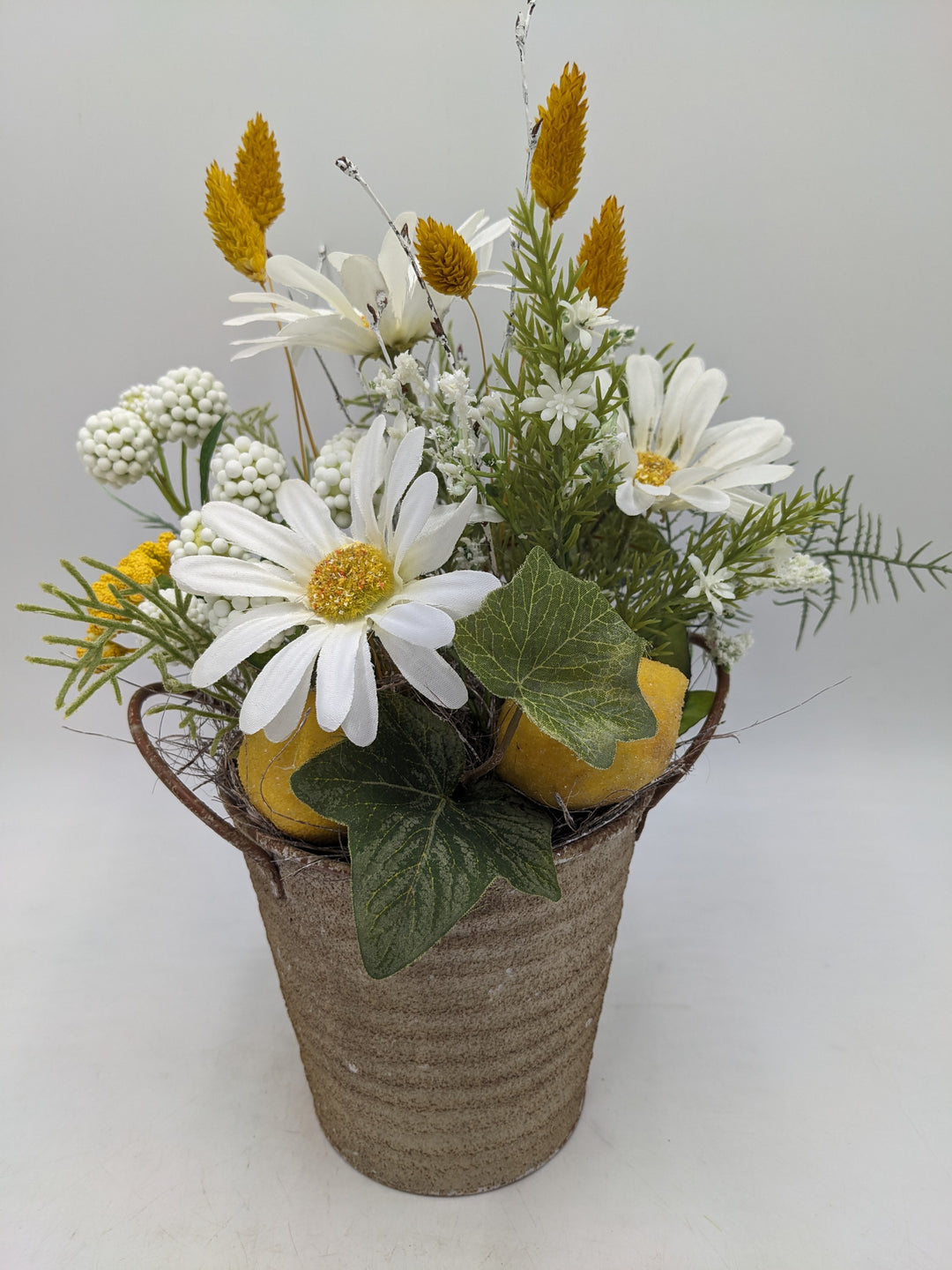 Frühlingsgesteck Margeriten Zitronen gelb weiss