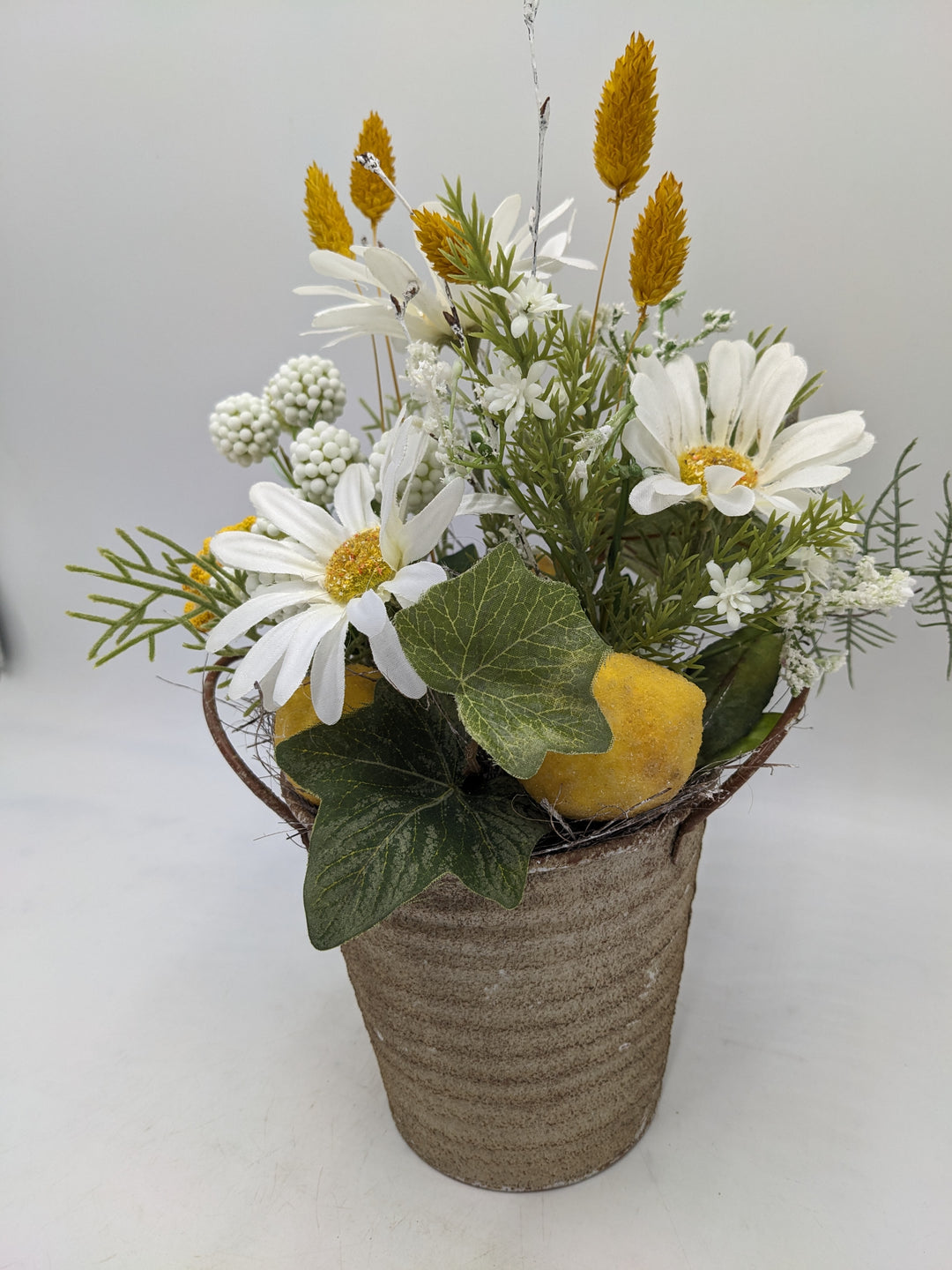 Frühlingsgesteck Margeriten Zitronen gelb weiss