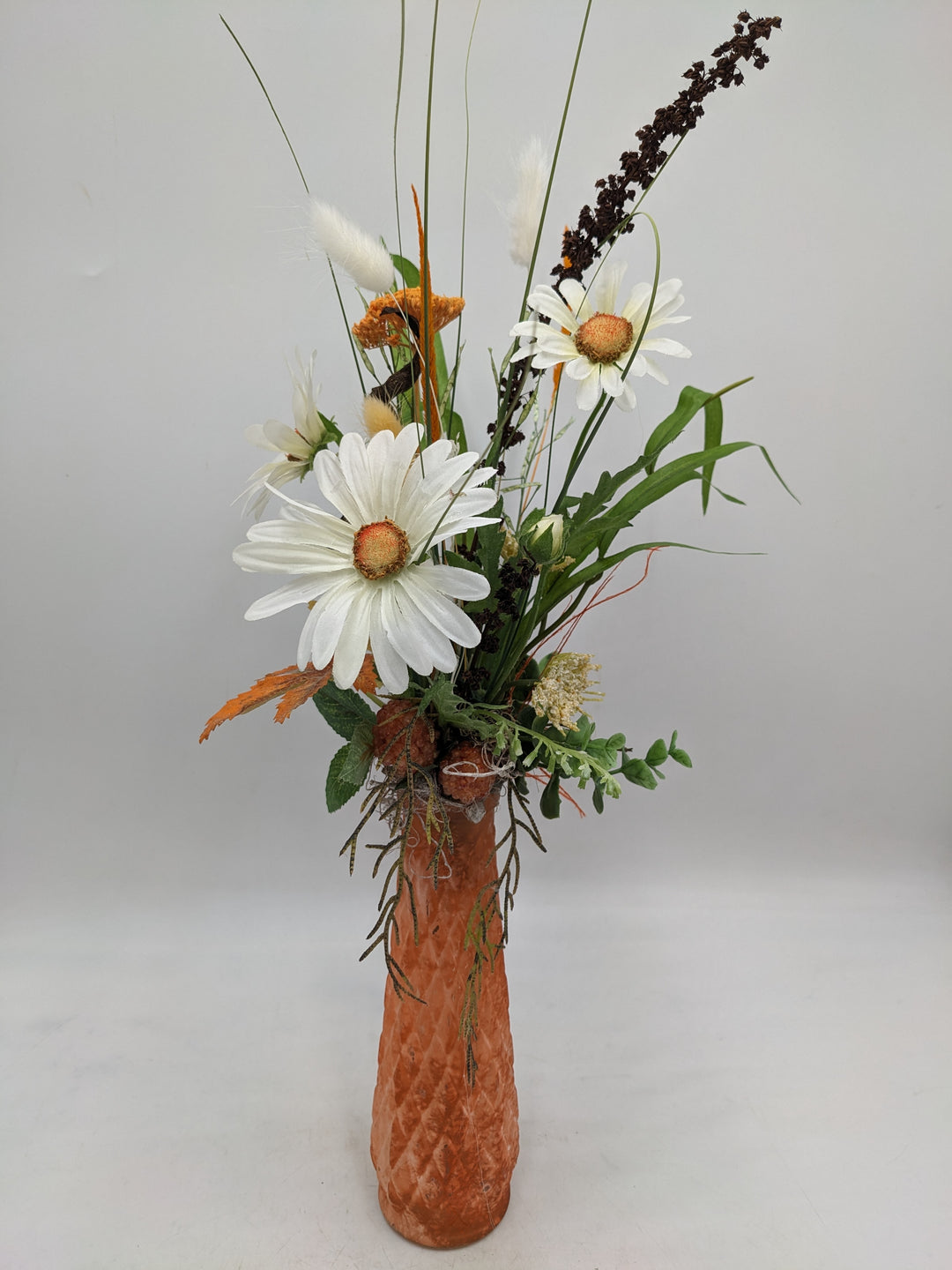Frühlingsgesteck Vase Margeriten Gräser orange