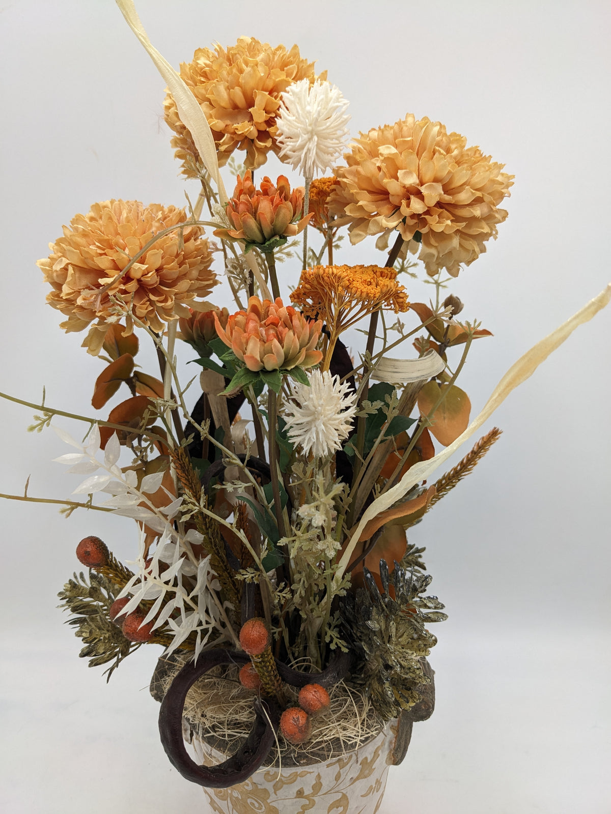 Nahaufnahme der apricotfarbenen Chrysanthemen, senffarbenen Schafgarbe, weißen Blätter und orangefarbenen Beeren
