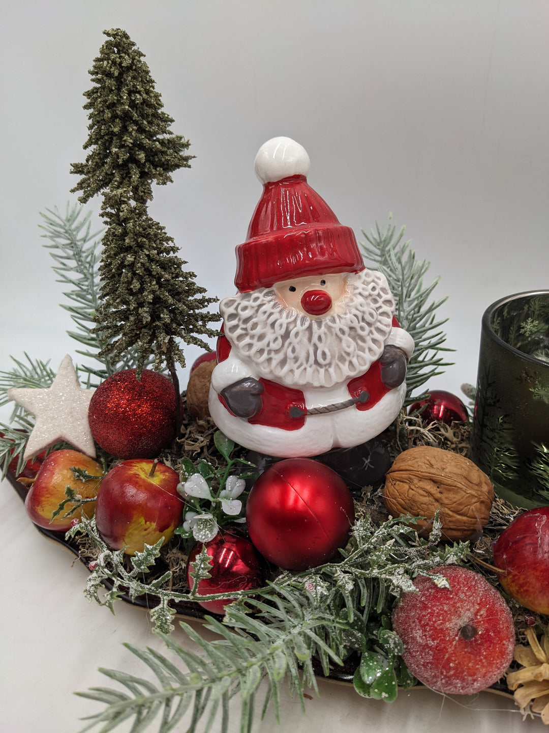Weihnachtsgesteck Teelicht Äpfel Weihnachtsmann Bäume