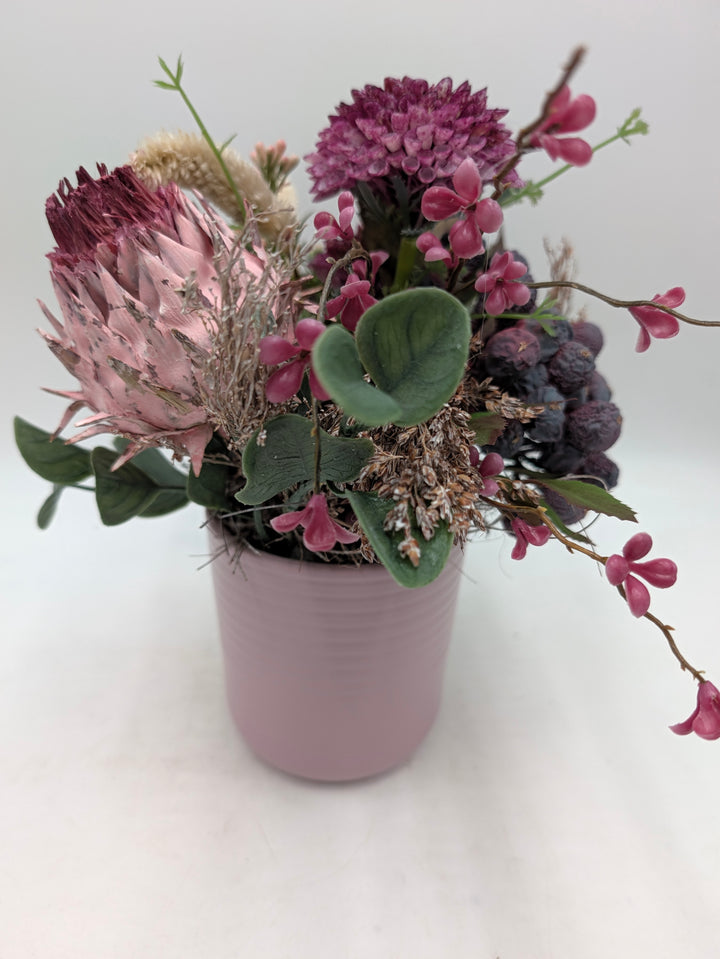 Frühlingsgesteck Artischocke Gräser lila rosa