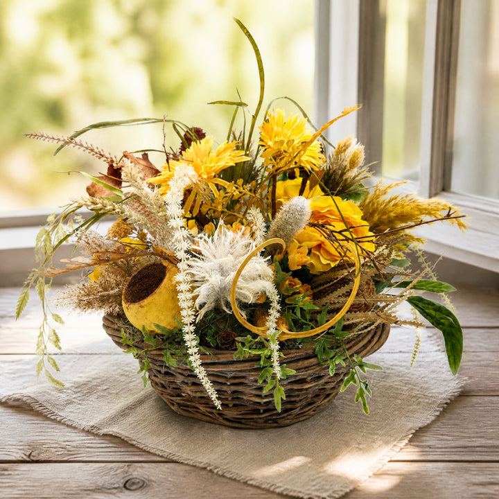Szene Sommergesteck Gerbera Distel Banksia Gräser gelb natur im Korb