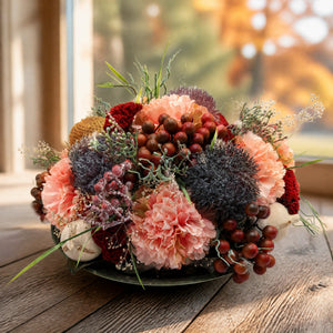 Szene Herbstgesteck Nelken Beeren Gräser lachs lila in Schale