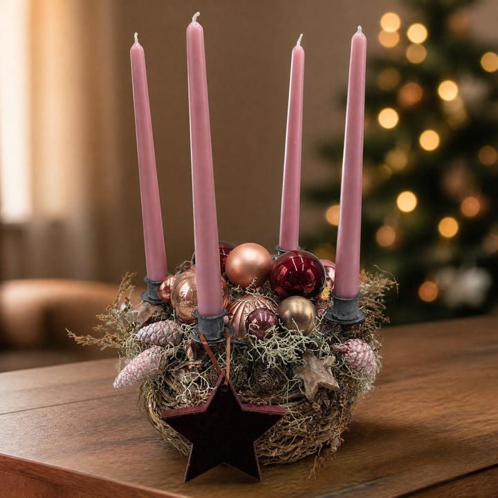 Szene Adventsgesteck rosa mit Kugeln, Sternen und Zapfen im Geäst