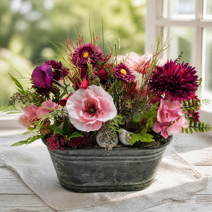 Szene Sommergesteck Bellis Clematis Schnecke rosa lila in Zinkschale