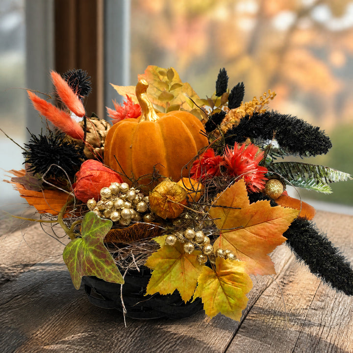 Szene Herbstgesteck Kürbis Blüten Laub orange schwarz gold im Korb
