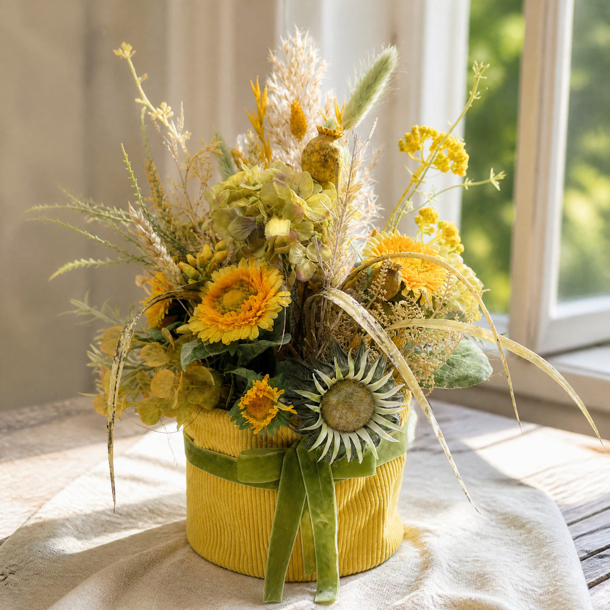 Szene Sommergesteck Gerbera Hortensie Mohnkapseln gelb grün im Topf