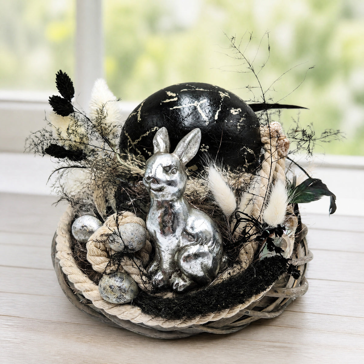 Szene Ostergesteck Hase Straußenei Federn schwarz silber im Korb