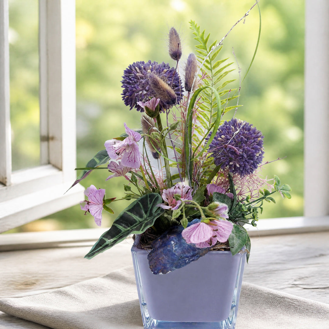 Szene Sommergesteck Allium Blüten Farn lila rosa im Glas