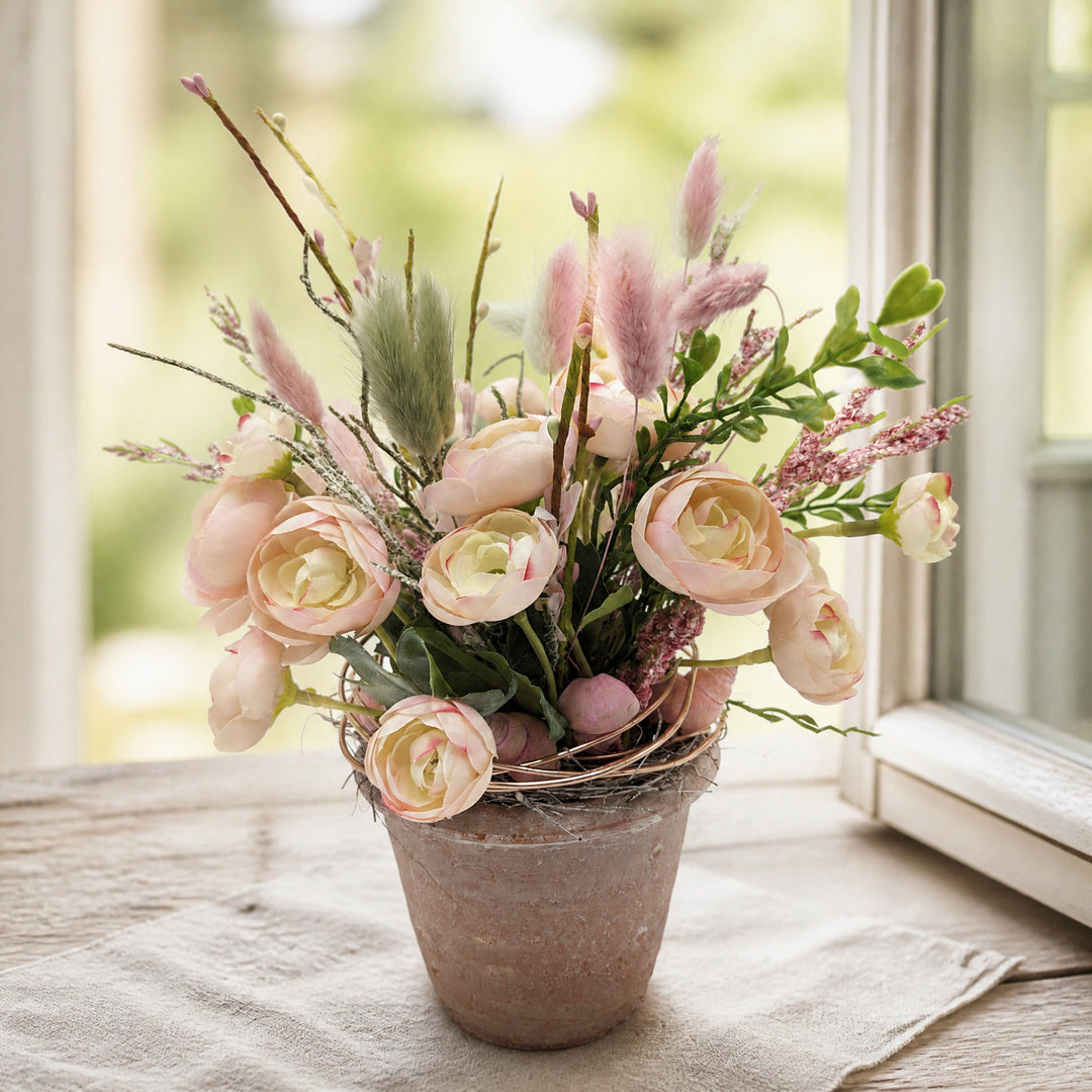 Szene Sommergesteck Ranunkeln Schnecke Salbei rosa apricot im Topf