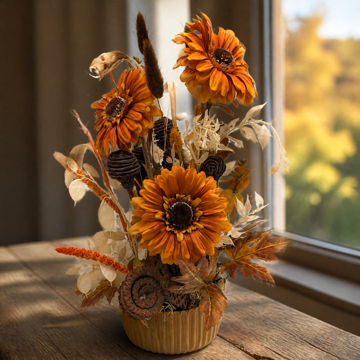 Szene Herbstgesteck Gerbera Zapfen Gräser orange braun