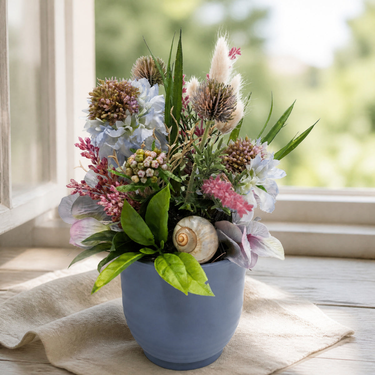 Szene Sommergesteck Hortensie Distel Schnecke blau rosa