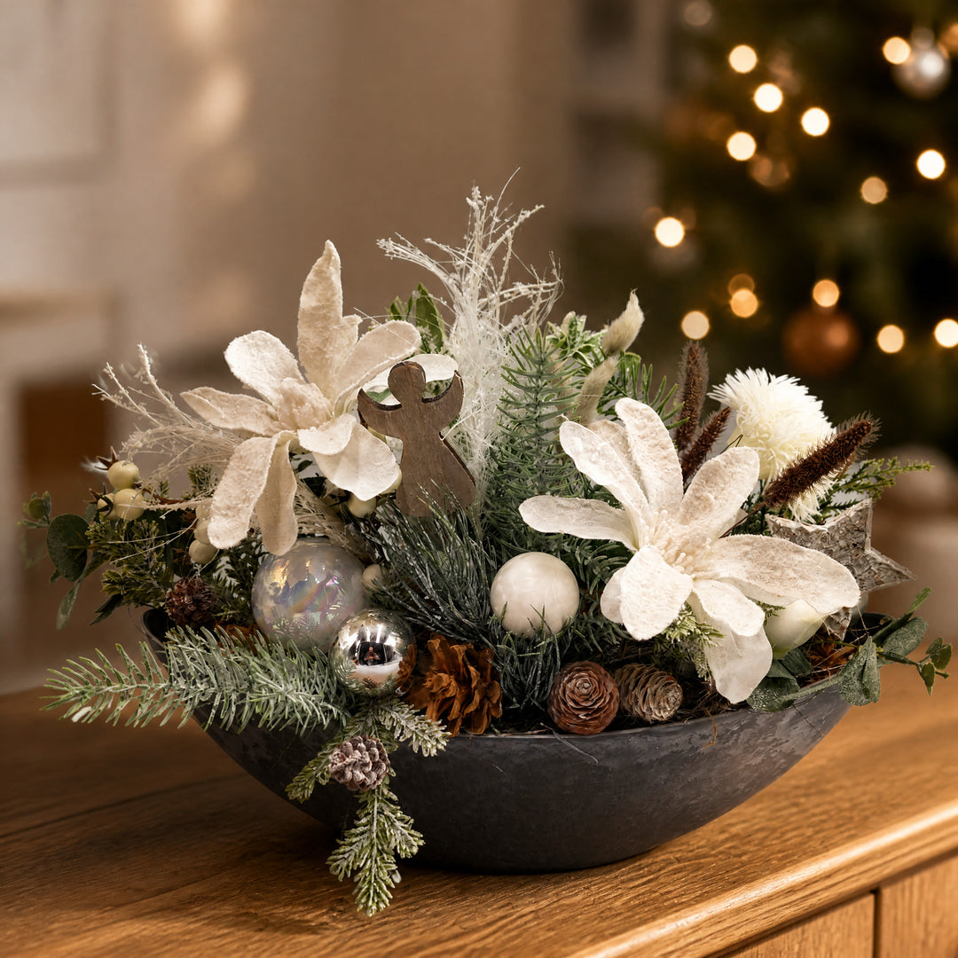Szene Weihnachtsgesteck Magnolie Engel Kugeln Zapfen weiß grau