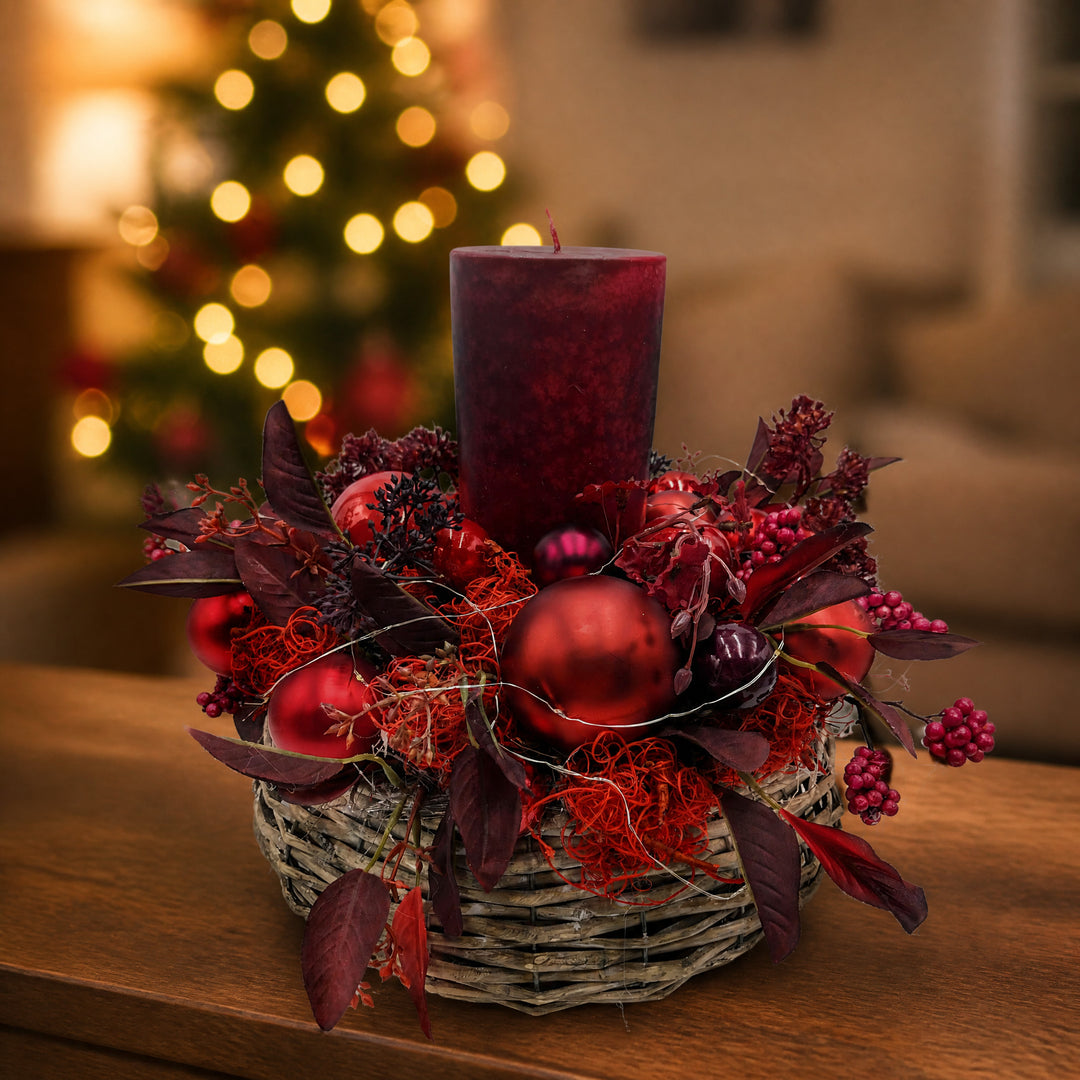 Szene Weihnachtsgesteck LED Kerze Kugeln Blätter Beeren rot