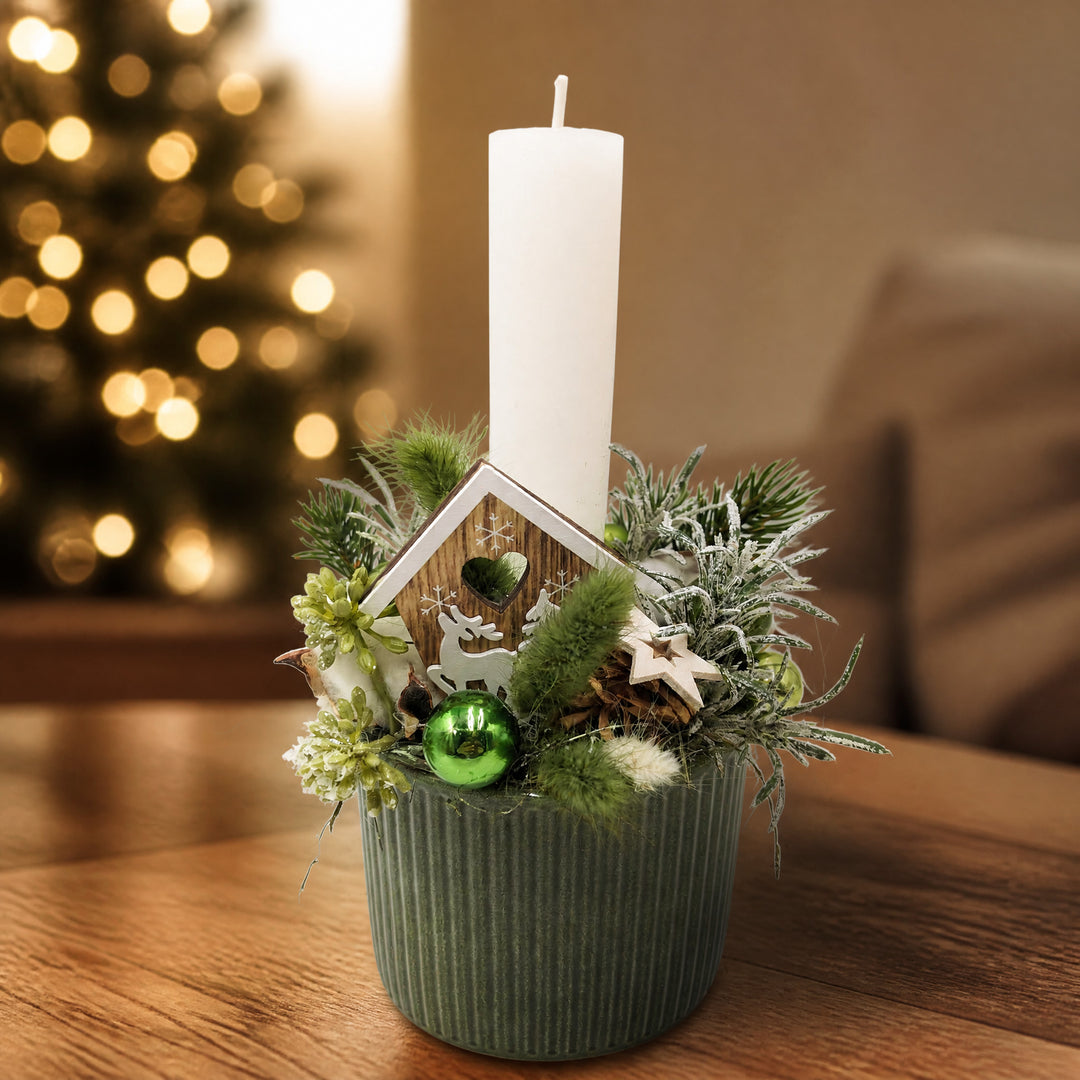 Szene Weihnachtsgesteck Kerze Kugel Stern Haus grün weiß