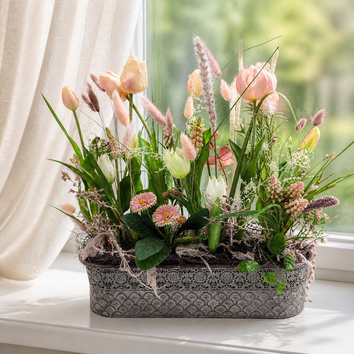 Szene Frühlingsgesteck Tulpen Bellis Gräser rosa creme im Metallkasten