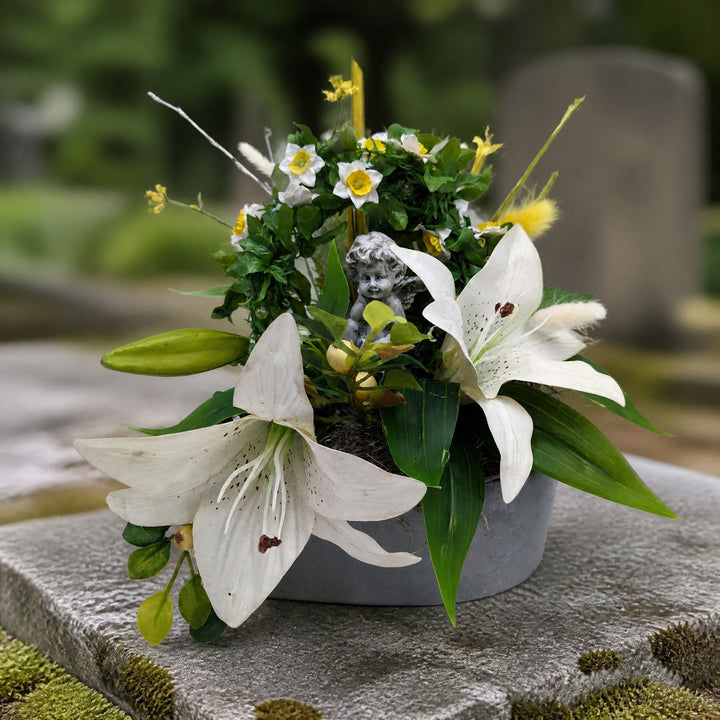Szene Trauergesteck Engel Lilien Narzissen weiss grün
