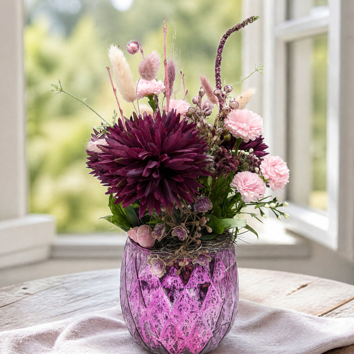 Szene Sommergesteck Nelken Dahlie Gräser lila rosa im Glas