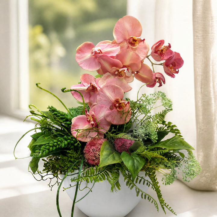 Szene Frühlingsgesteck Orchideen Sedum Farn rosa grün in weißer Schale