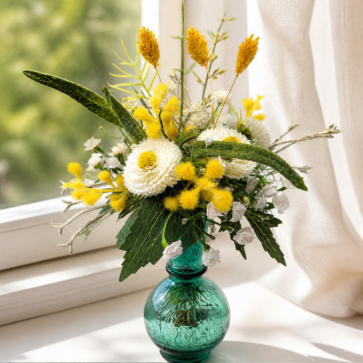 Szene Frühlingsgesteck Vase Gräser Bellis türkis gelb weiß