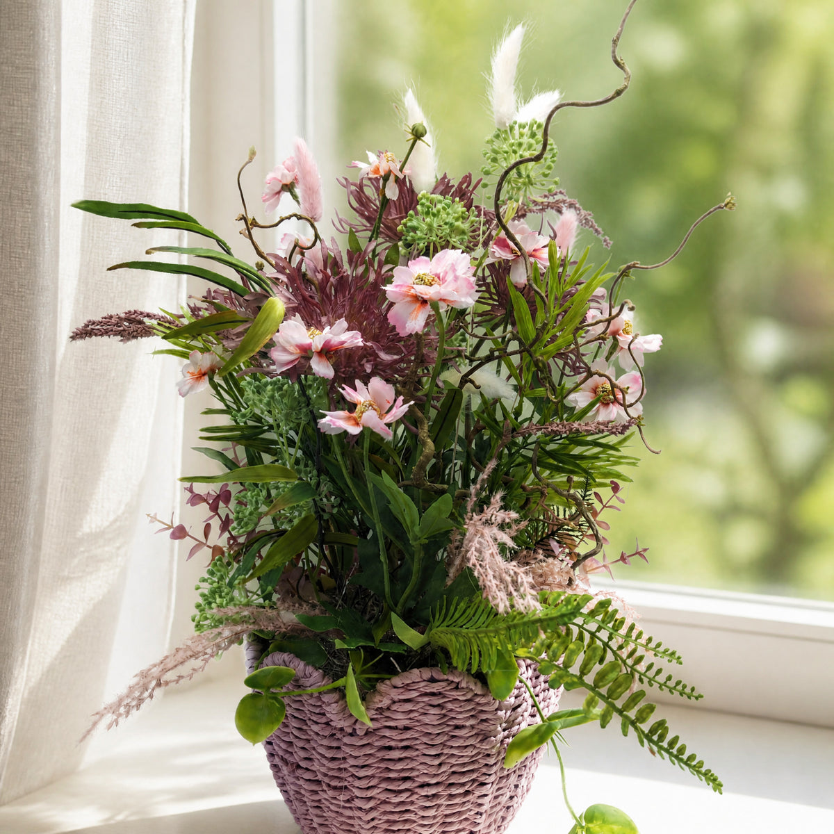 Szene Frühlingsgesteck Gräser Farn Blüten im Korb rosa lila