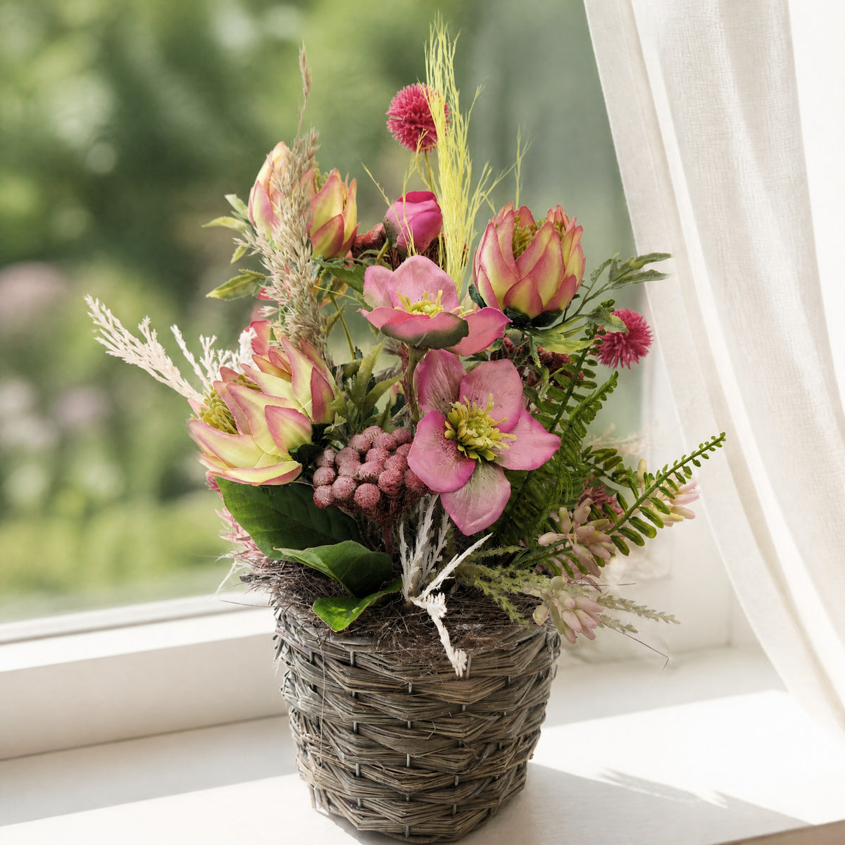 Szene Frühlingsgesteck Christrose Protea Gräser rosa grün im Korb