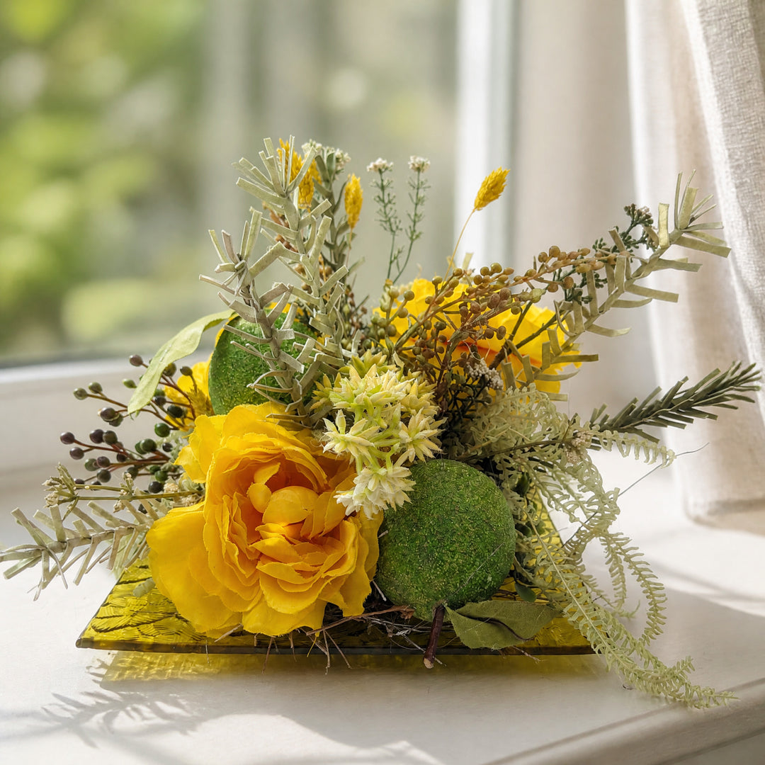 Szene Frühlingsgesteck Rosen Limonen Glasteller gelb grün