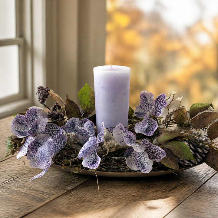 Szene Herbstgesteck Orchidee Zapfen Beeren flieder lila mit Kerze