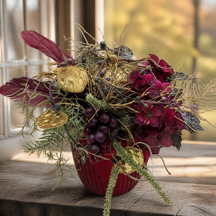 Szene Herbstgesteck Kürbis gold Hortensien Trauben bordeaux