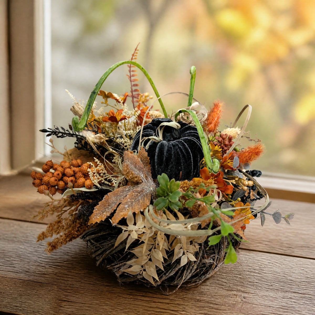 Szene Herbstgesteck Samtkürbis Beeren Gräser schwarz orange
