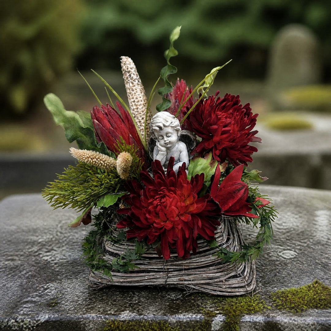 Szene Trauergesteck Engel Chrysanthemen Protea rot grau