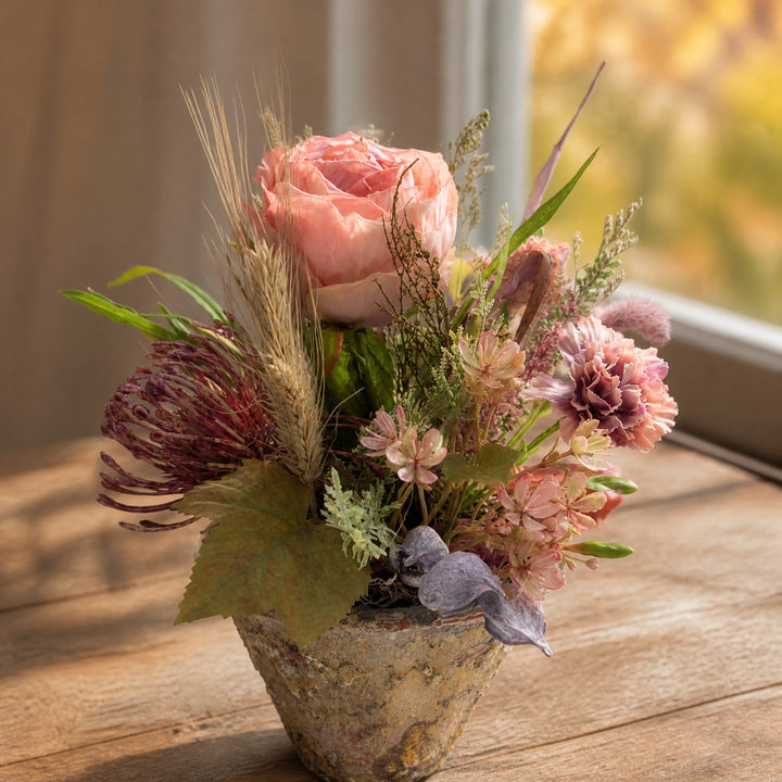 Szene Herbstgesteck Rose Nelke Weizen Gräser apricot rosa im Topf