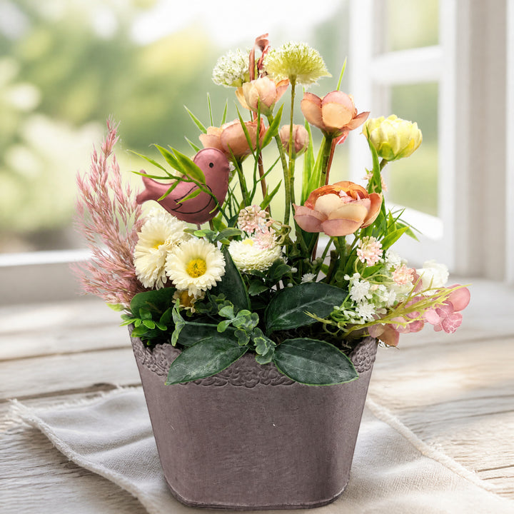 Szene Tischgesteck Sommergesteck Vogel Ranunkeln Bellis Gräser rosa creme