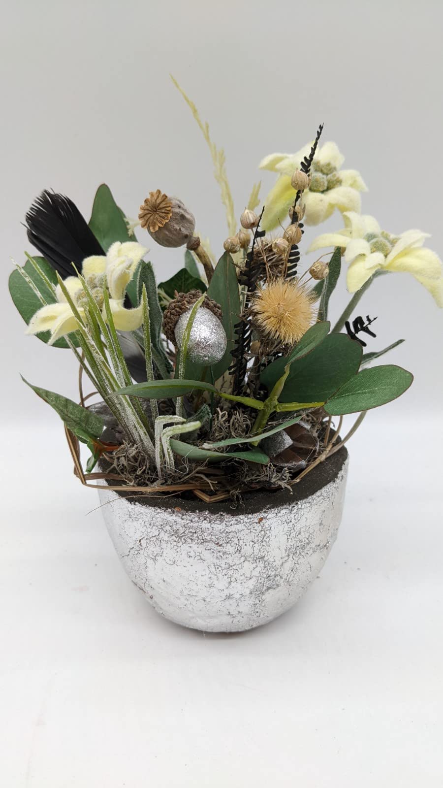 Ostergesteck Frühlingsgesteck Blumenarrangement Edelweiß Feder Mohnkapsel Gräser gelb grün silber