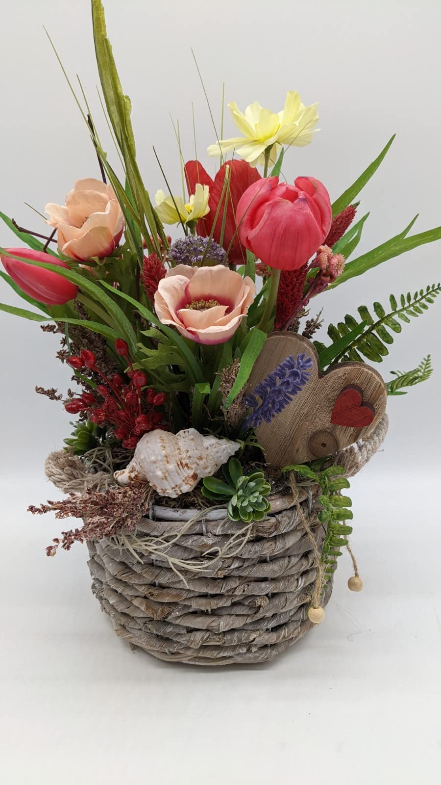 Frühlingsgesteck im Korbtopf mit pinken Tulpen, apricotfarbenen Anemonen, gelber Narzisse und weißer Muschel