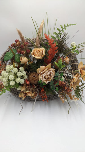 Breites Herbstgesteck von vorn: Rosen in Apricot, weiße Dolde, Efeu, rote Brombeeren und orange Federähre