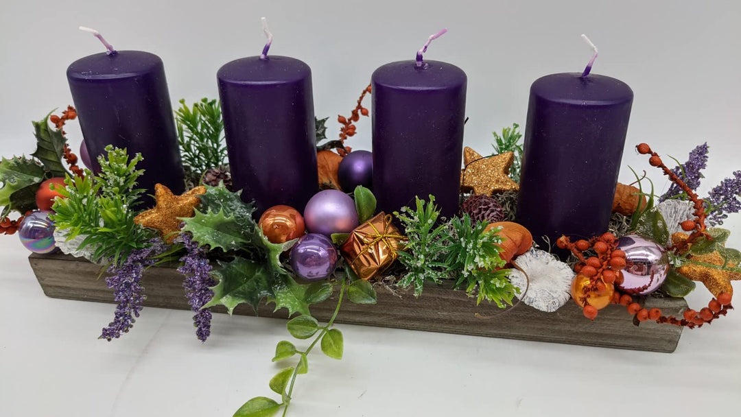 Weihnachtsgesteck Adventsgesteck Tischgesteck Kugeln Sterne Geschenke Kerzen lila orange