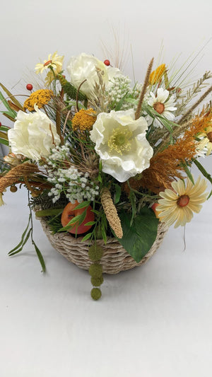 Herbstgesteck von vorn: weiße Mohnblüten, gelbe Schafgarbe, rostbraune Gräser und rote Beeren im Flechtkorb
