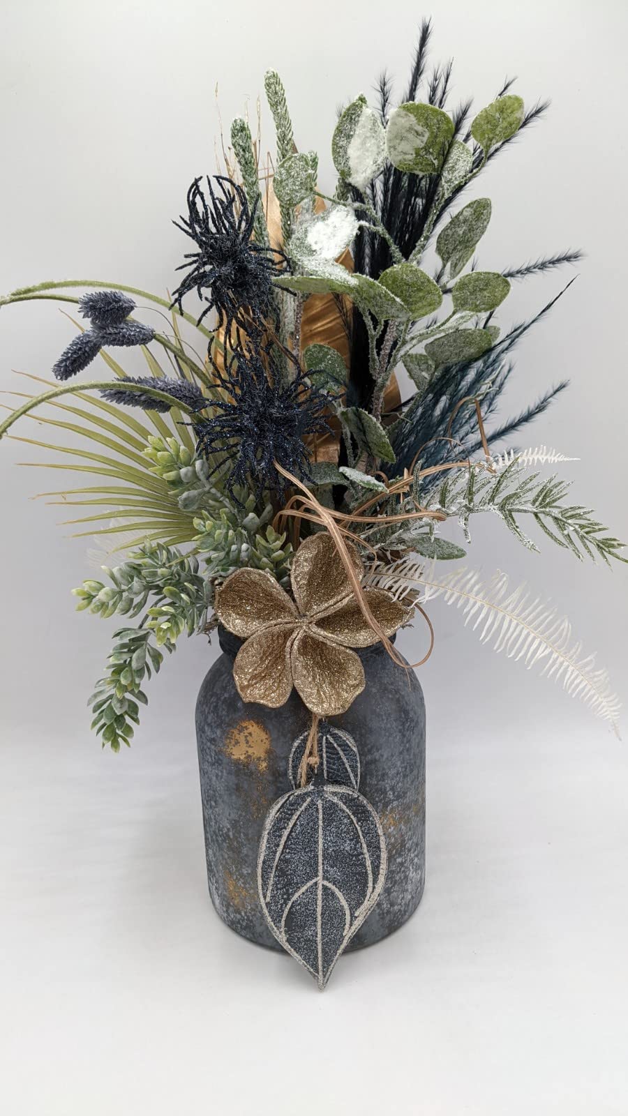 Hohes Herbstgesteck mit blauen Disteln, Getreide und bereiften Blättern in grau-goldener Vase