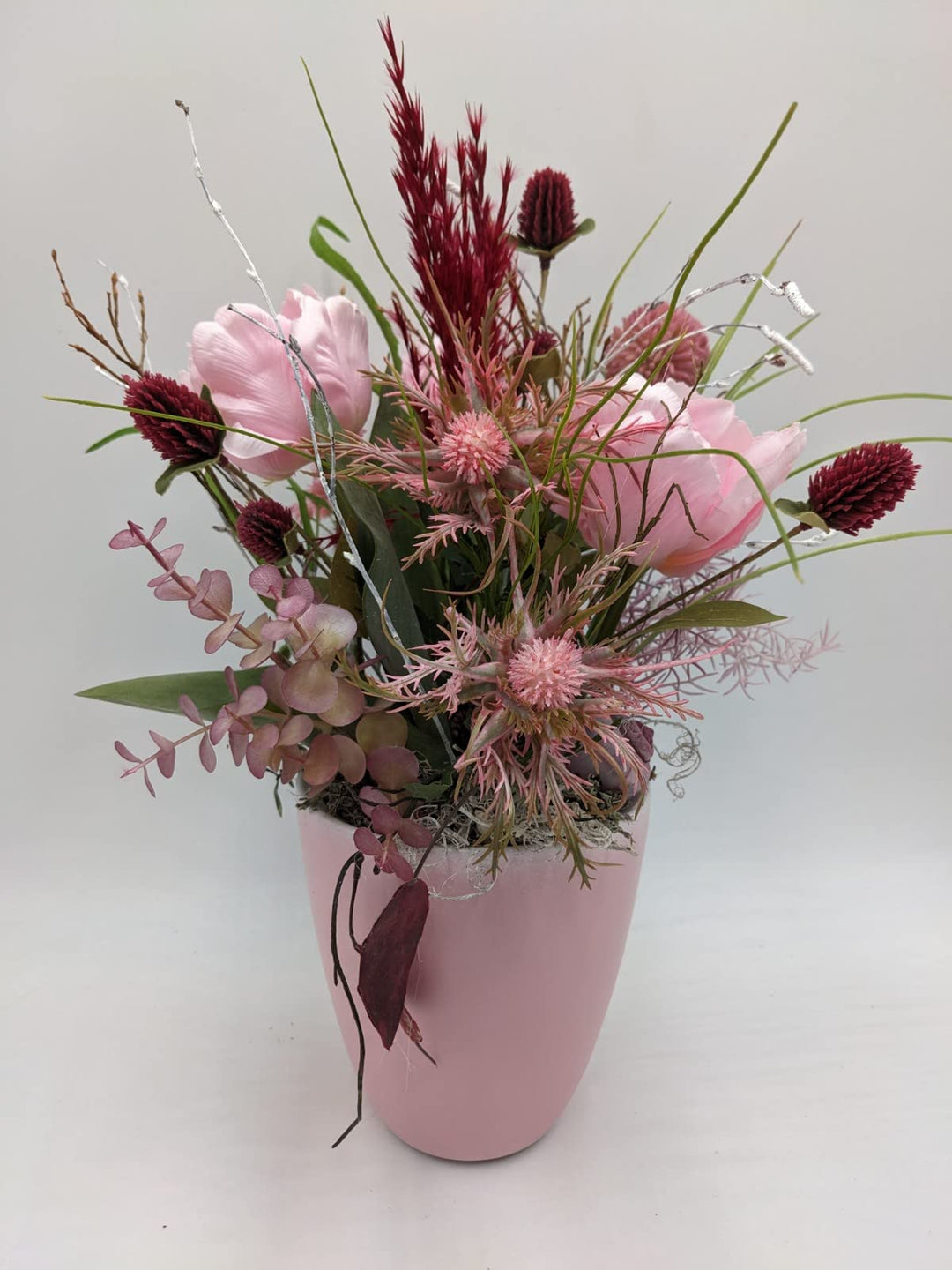 Tischgesteck Frühlingsgesteck Schnecke Blüten Beiwerk Gräser rosa dunkelrot