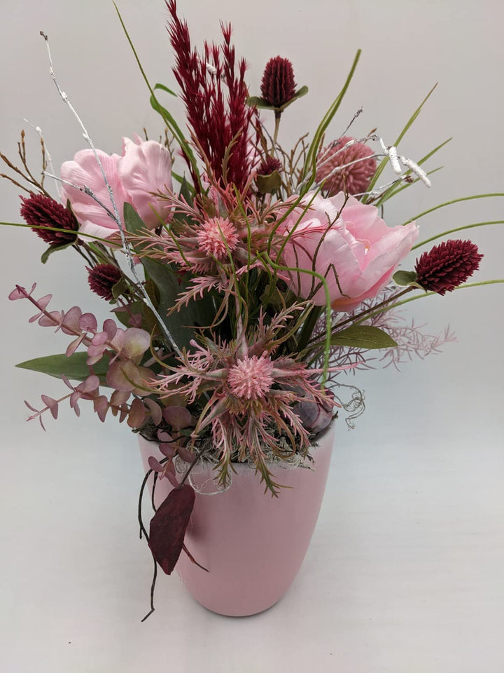 Tischgesteck Frühlingsgesteck Schnecke Blüten Beiwerk Gräser rosa dunkelrot